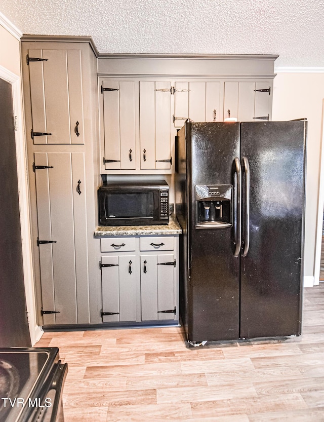 kitchen featuring ornamental molding, a textured ceiling, gray cabinetry, and black appliances