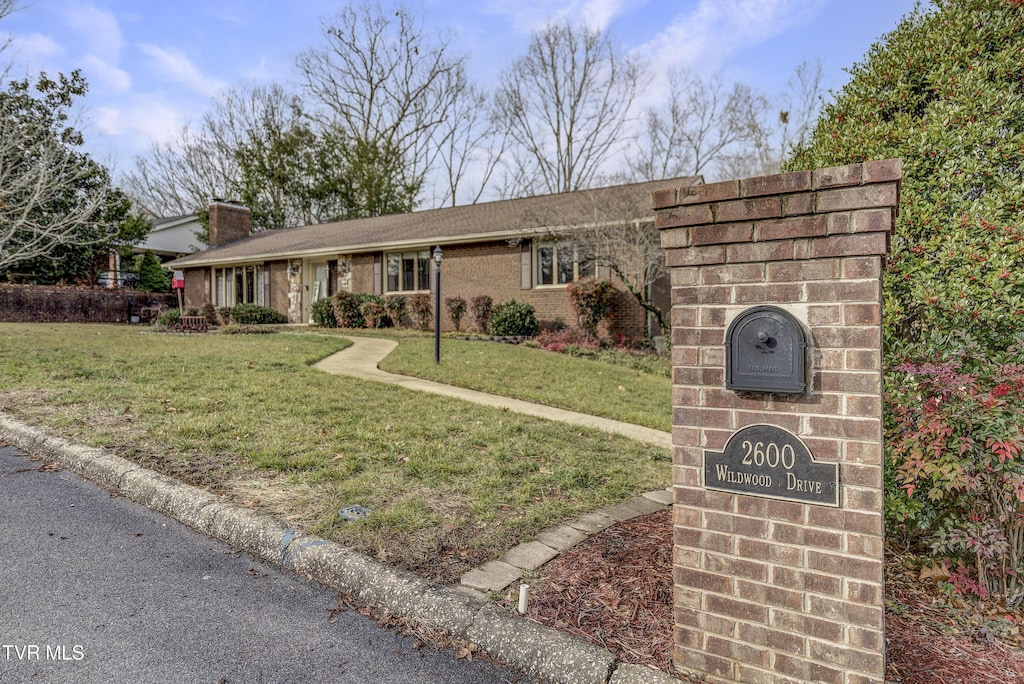 single story home featuring a front lawn