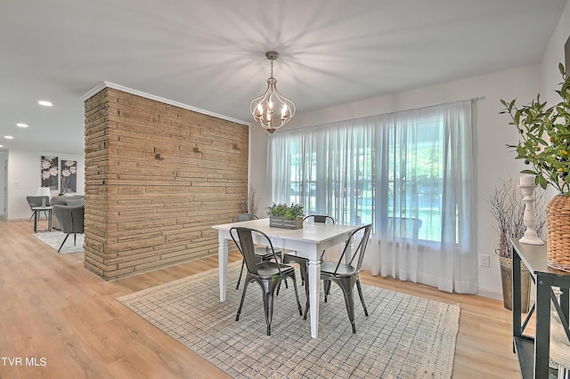 dining area with a notable chandelier and light hardwood / wood-style floors