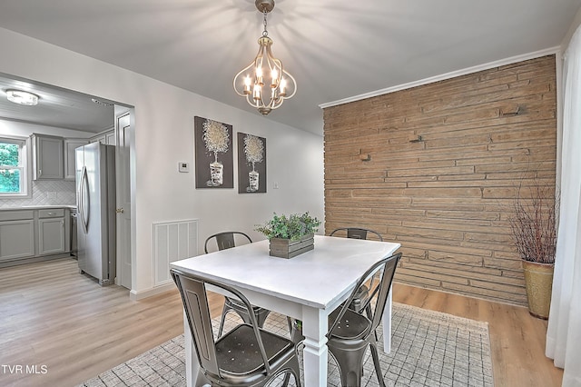 dining room featuring a notable chandelier and light wood-type flooring