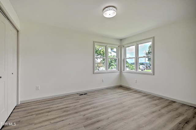 unfurnished bedroom with light hardwood / wood-style floors and a closet