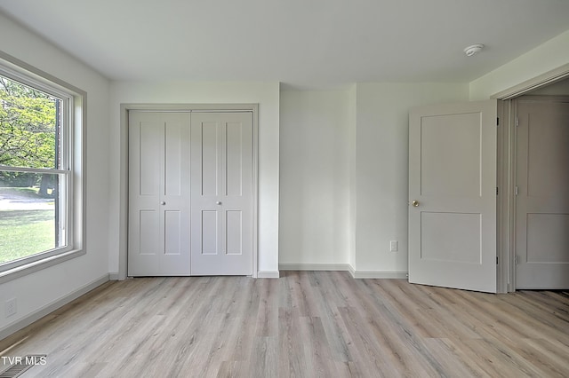 unfurnished bedroom featuring light hardwood / wood-style floors and a closet