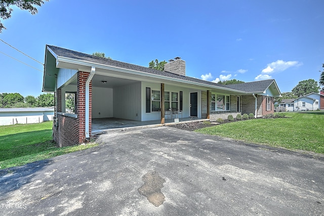 ranch-style home featuring a carport, a porch, and a front yard