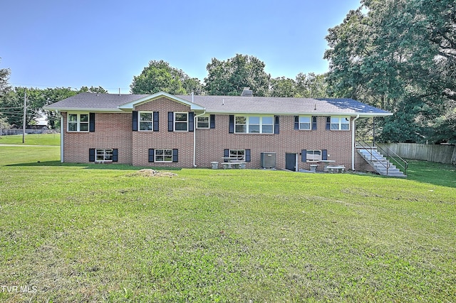 rear view of house featuring a yard and central air condition unit