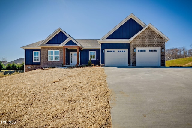 craftsman-style house with a garage, board and batten siding, and brick siding