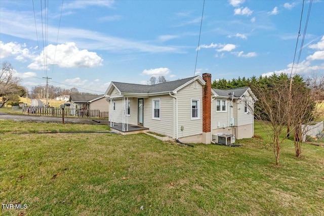 back of house featuring central AC and a yard