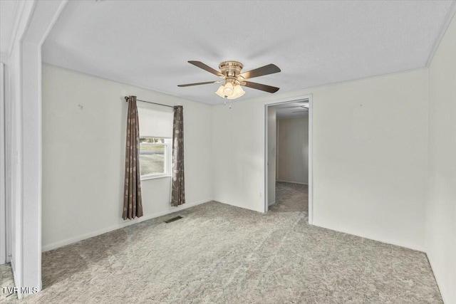 carpeted spare room featuring ceiling fan and a textured ceiling