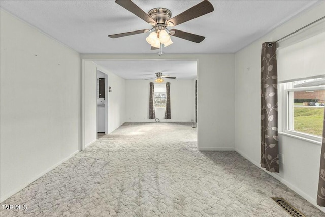 spare room featuring light carpet, ceiling fan, and a healthy amount of sunlight