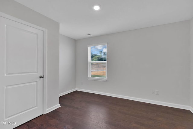 unfurnished room featuring dark wood-style floors and baseboards