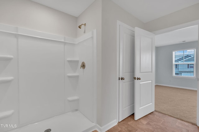 bathroom with baseboards and a shower