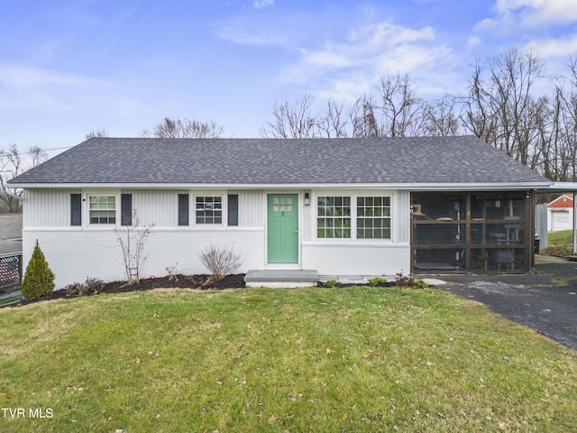 ranch-style house with a front yard and a sunroom