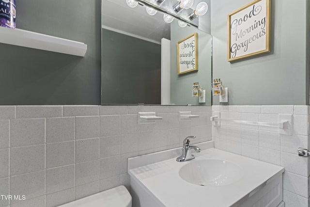 bathroom with tile walls, sink, and toilet