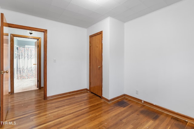 empty room with ornamental molding and hardwood / wood-style floors