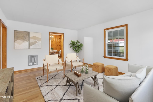 living room with heating unit and light wood-type flooring