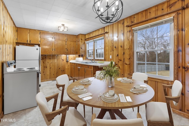 dining space featuring washer / clothes dryer, plenty of natural light, and wooden walls