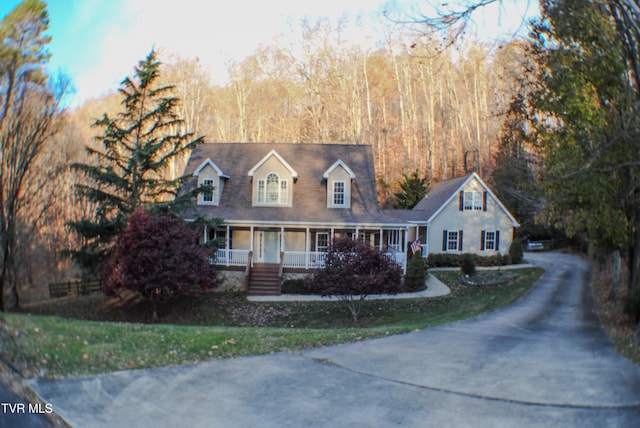 cape cod-style house with covered porch