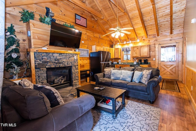 living room with ceiling fan, wooden walls, beam ceiling, wooden ceiling, and light hardwood / wood-style floors