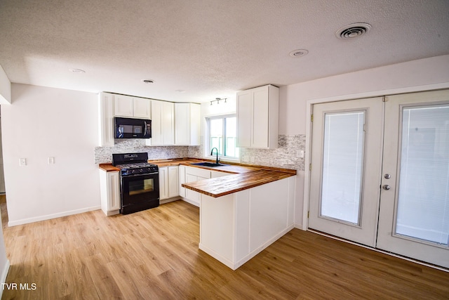 kitchen featuring black appliances, white cabinets, french doors, and wooden counters