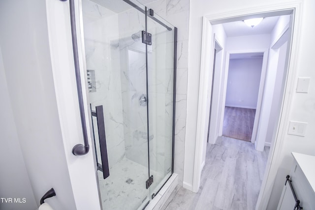 bathroom featuring an enclosed shower and wood-type flooring