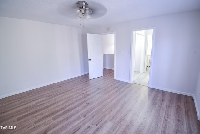 empty room with ceiling fan and light hardwood / wood-style floors