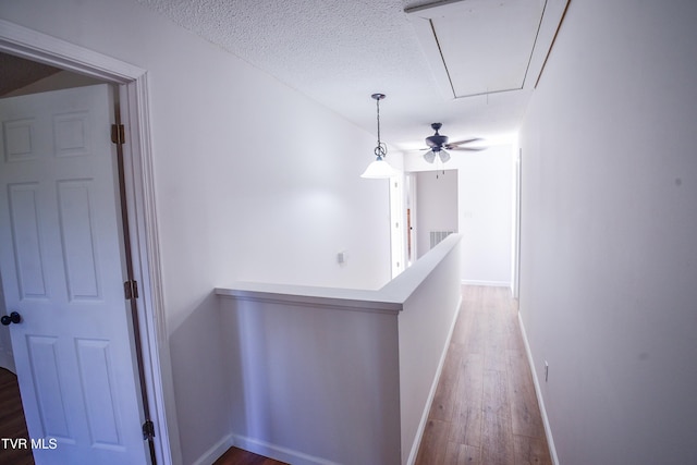 corridor featuring a textured ceiling and hardwood / wood-style flooring