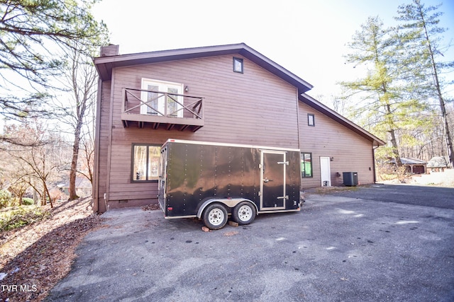 back of property featuring a balcony and cooling unit