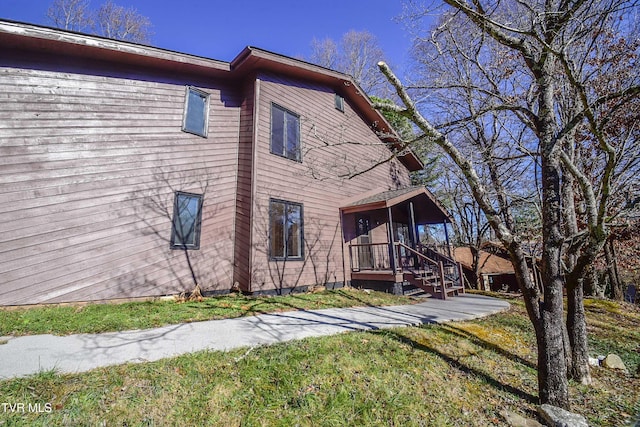 view of property exterior featuring a sunroom and a lawn