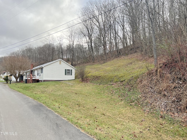 view of side of home with a yard