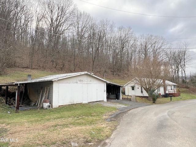 view of outbuilding featuring a carport and a lawn