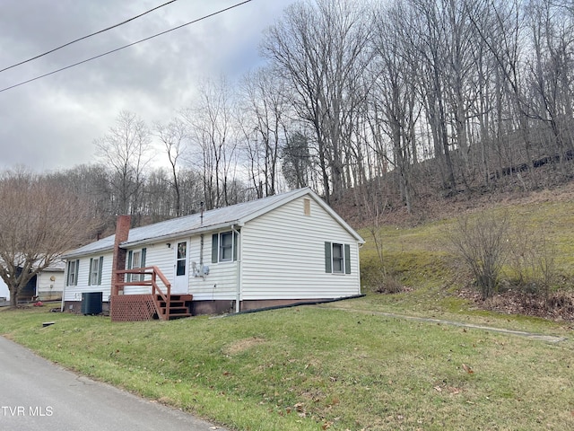 view of front of home with central AC and a front lawn