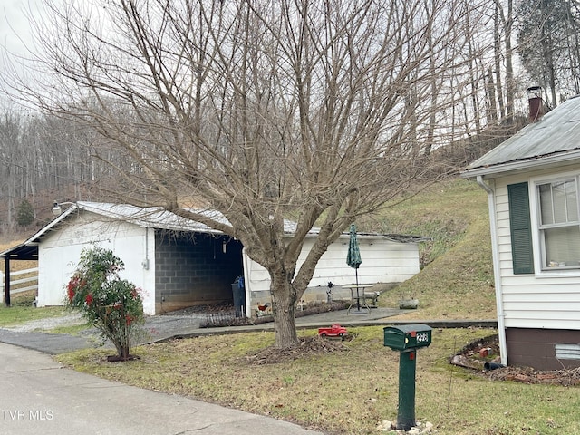 view of side of property with an outbuilding and a yard