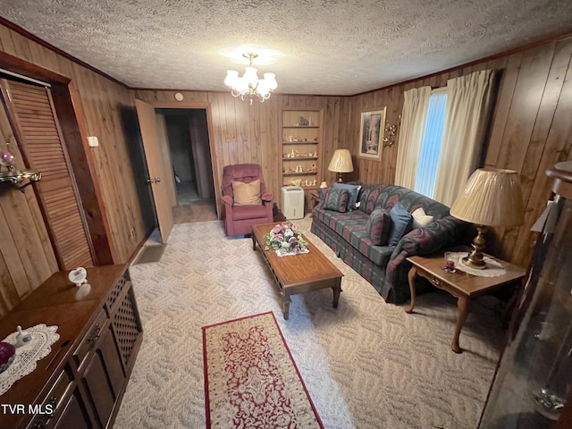 living room featuring wood walls, light colored carpet, a textured ceiling, and a chandelier