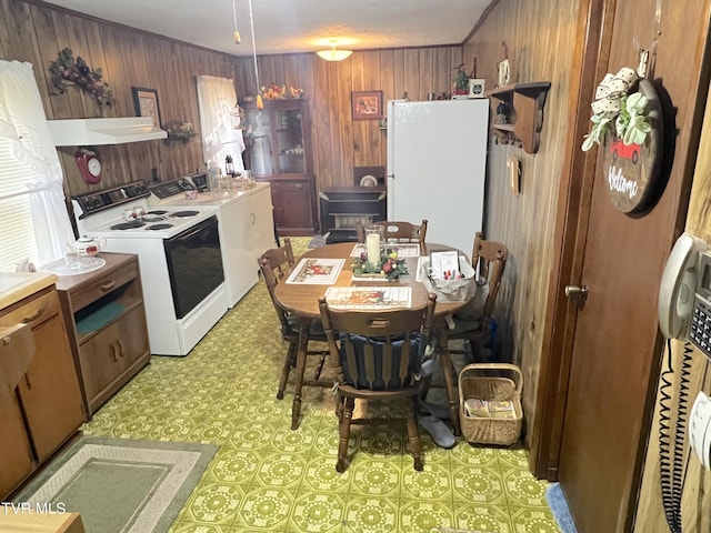 kitchen with white appliances, washer / clothes dryer, extractor fan, and wooden walls