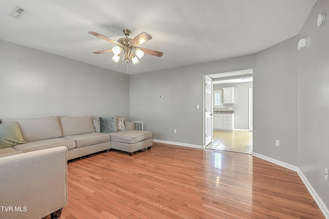 living room featuring ceiling fan and light hardwood / wood-style floors