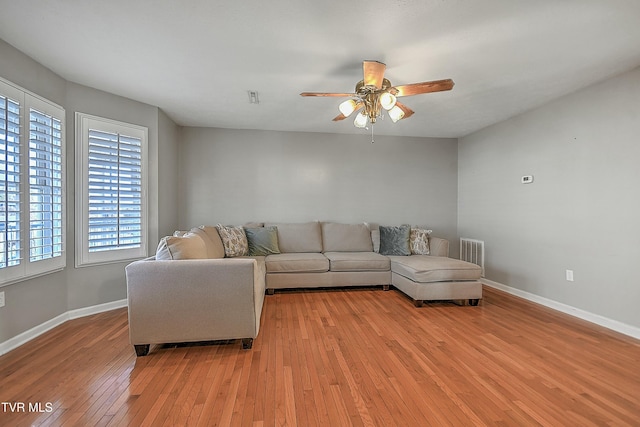 living room with ceiling fan and light hardwood / wood-style flooring