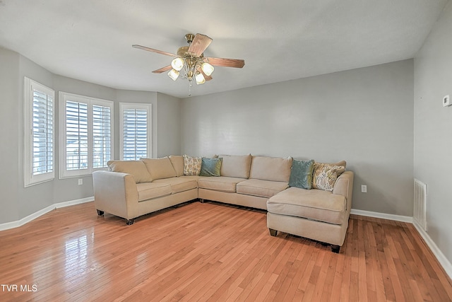 living room with light hardwood / wood-style flooring and ceiling fan