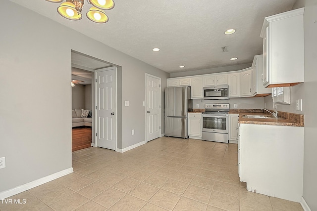 kitchen with white cabinets, light tile patterned flooring, sink, and appliances with stainless steel finishes