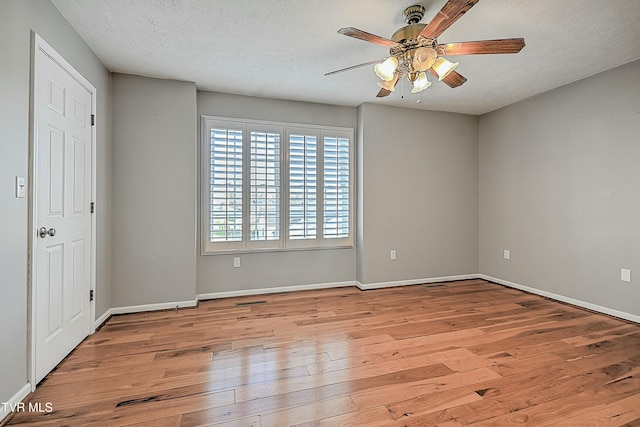 unfurnished room with ceiling fan, light hardwood / wood-style flooring, and a textured ceiling