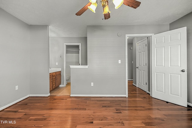 unfurnished room featuring ceiling fan, wood-type flooring, and a textured ceiling