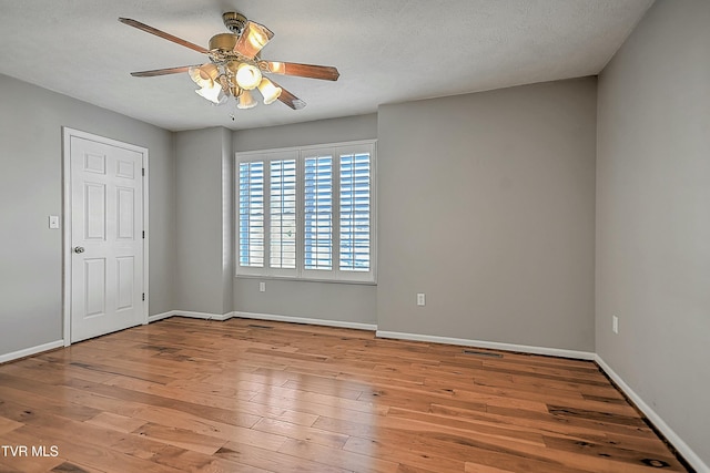 unfurnished room featuring a textured ceiling, light wood-type flooring, and ceiling fan