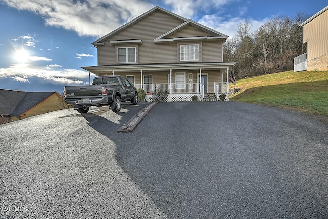 view of front of house with covered porch and a front lawn