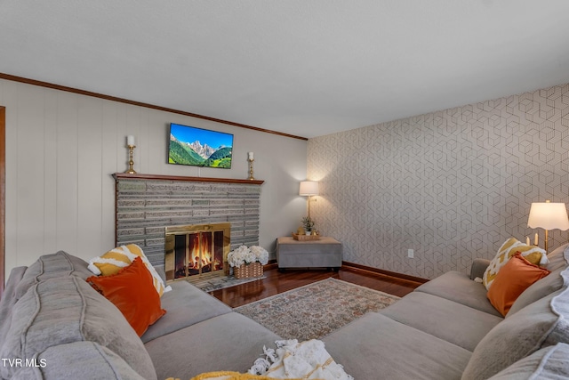 living room featuring crown molding, a fireplace, and wood-type flooring