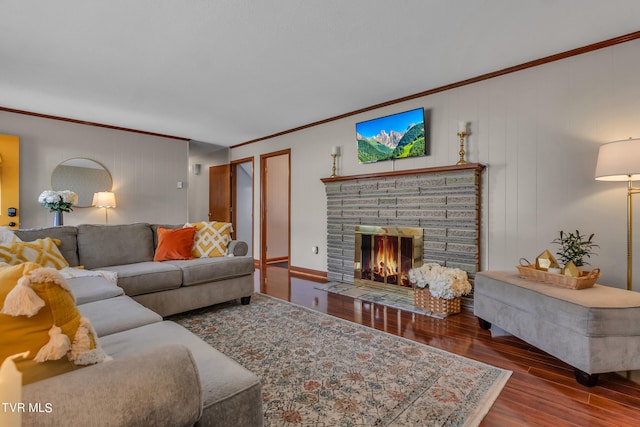 living room featuring hardwood / wood-style flooring, crown molding, and a fireplace