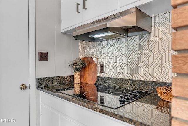 kitchen with white cabinets, black electric cooktop, dark stone counters, and exhaust hood