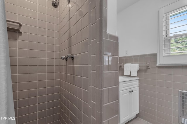 bathroom featuring heating unit, curtained shower, vanity, and tile walls