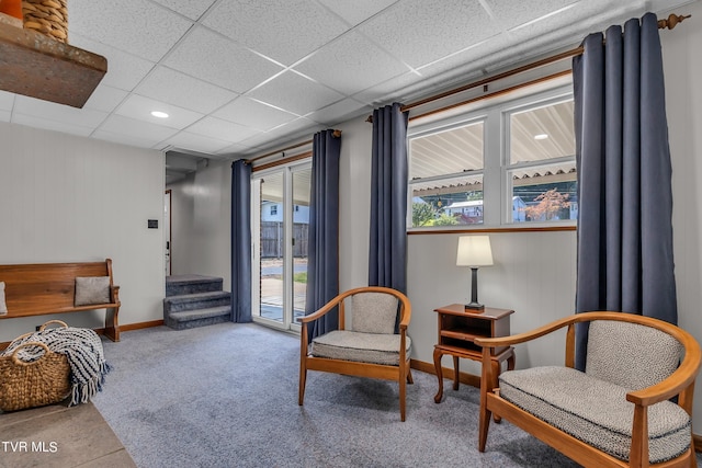 sitting room with a paneled ceiling and light carpet