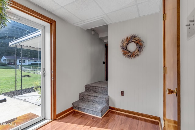 interior space featuring a paneled ceiling and light hardwood / wood-style flooring