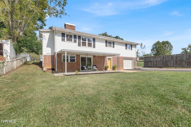 rear view of property featuring a lawn, a garage, and a patio