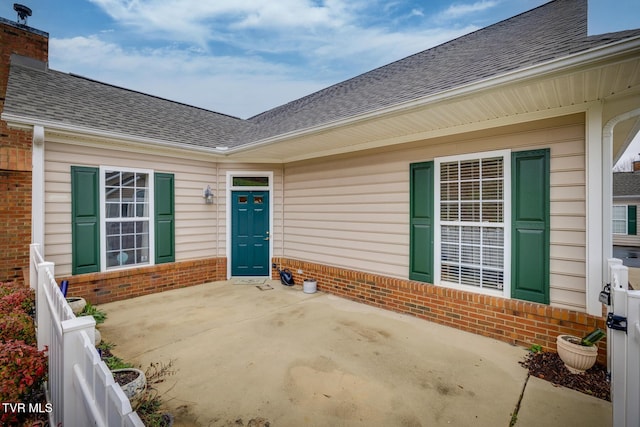 view of exterior entry with a patio area