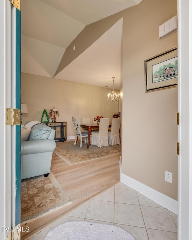 interior space featuring vaulted ceiling, a notable chandelier, and light tile patterned flooring